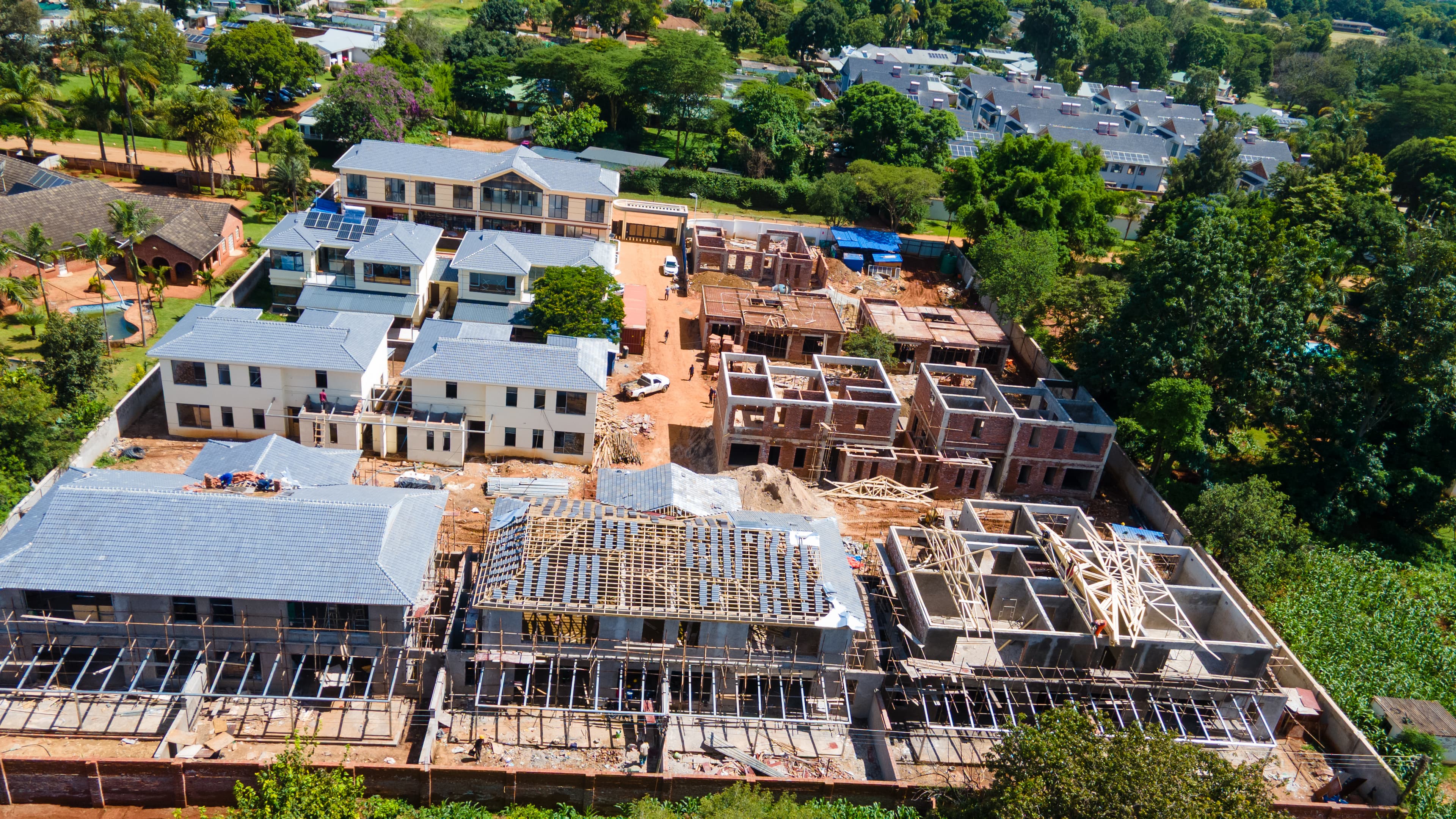 Construction progress aerial showing foundation work, steel structures, and crane operations
